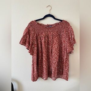 Deep red flutter top with white flower pattern and unique detail!